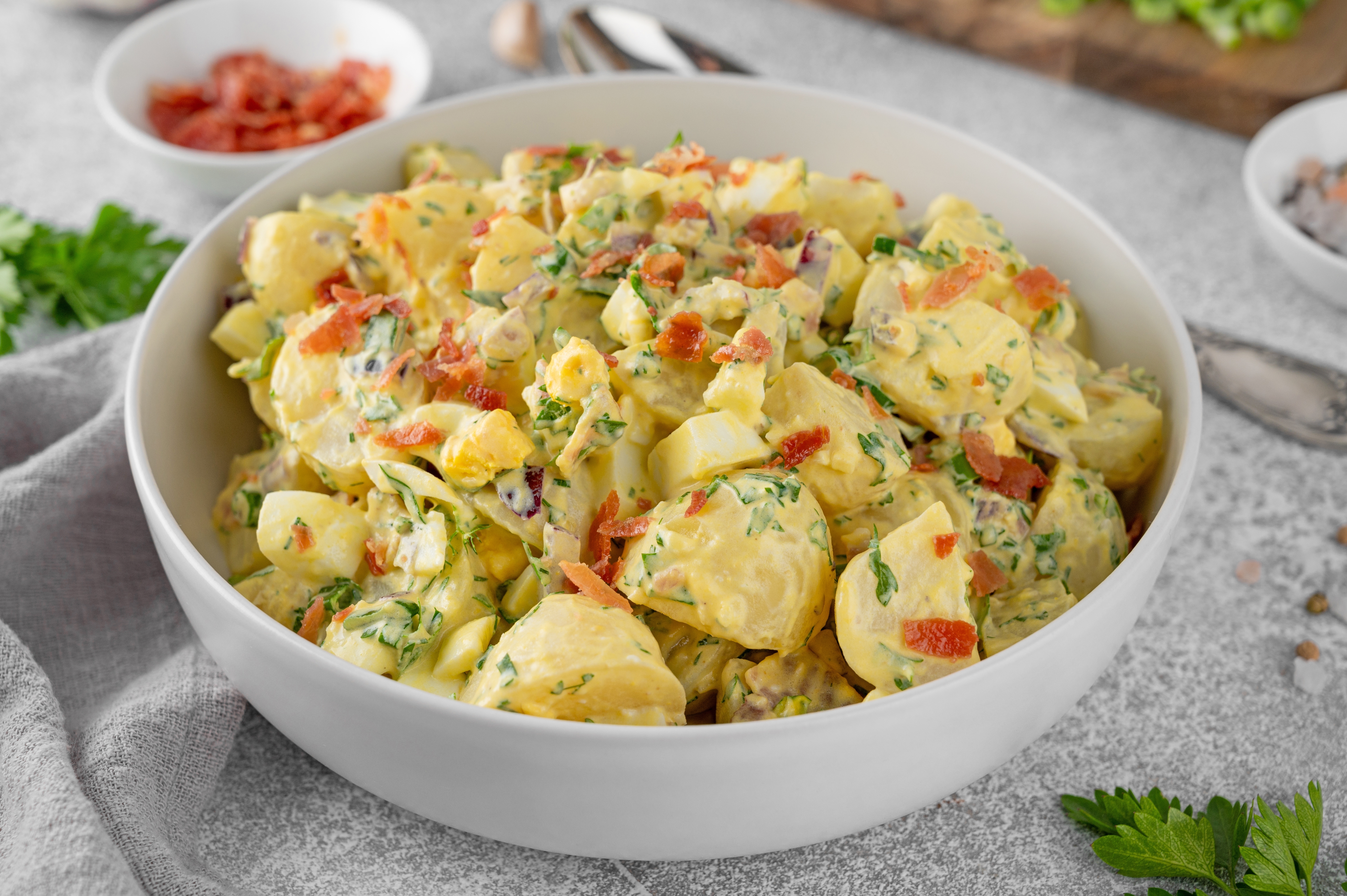 warm german potato salad with bacon in a white bowl